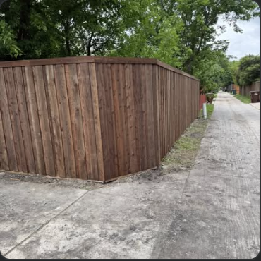 Stained cedar fence turning a corner near an alley